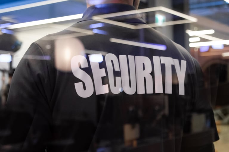 Male security officer standing in uniform at commercial building