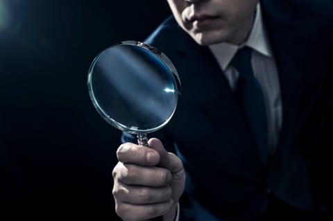 Professional reviewing evidence with magnifying glass
