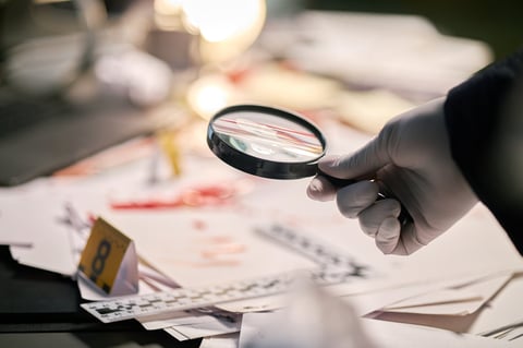 Magnifying glass examining documents in forensic investigation scene