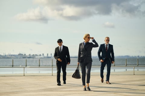 Executive walking with protective detail in business suits
