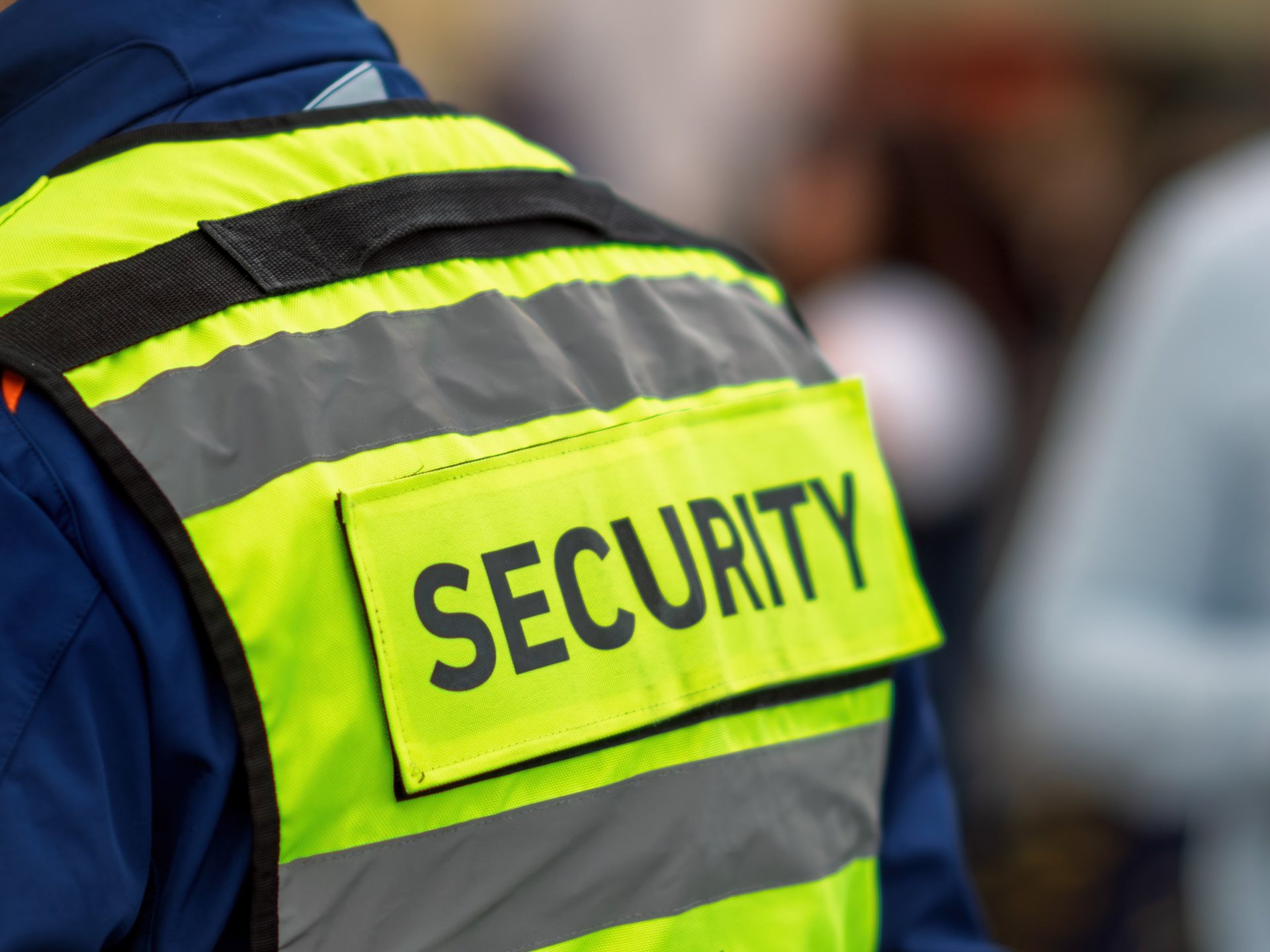 Security personnel wearing reflective vest with SECURITY text